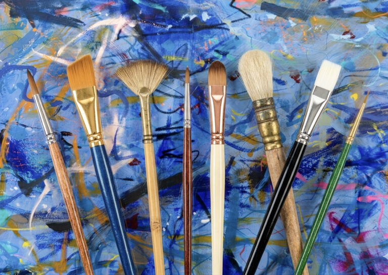 Abstract painting behind brushes, called Big Blue Breakthrough available at Little Pistol Studio